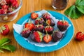 Dessert, fresh strawberries covered with dark chocolate, on a blue plate on a brown wooden background. Strawberry desserts Royalty Free Stock Photo