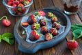 Dessert, fresh strawberries covered with dark chocolate, on a wooden plate on a brown background. Strawberry desserts Royalty Free Stock Photo