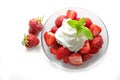 Dessert from fresh strawberries, whipped cream and peppermint garnish in a glass bowl on a white background Royalty Free Stock Photo