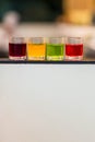 Dessert glass cup of colorful jelly served on blue wooden table. colored fruit jelly in glass cup . Eating colorful striped jelly