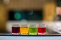 Dessert glass cup of colorful jelly served on blue wooden table. colored fruit jelly in glass cup . Eating colorful striped jelly