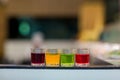 Dessert glass cup of colorful jelly served on blue wooden table. colored fruit jelly in glass cup . Eating colorful striped jelly