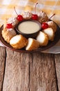 Dessert Leche frita with condensed milk and cherries closeup. Vertical