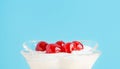 A dessert with maraschino cherry in a glass. Whipped cream, greek yogurt, ice cream. Close up
