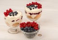 Dessert with mascarpone, cream, and berries in the glass cups on the wooden background. Royalty Free Stock Photo