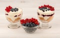 Dessert with mascarpone, cream, and berries in the glass cups on the wooden background. Royalty Free Stock Photo