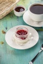 Dessert panna cotta with cherry jam and cup of black tea on blue wooden table Royalty Free Stock Photo