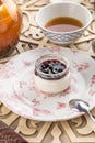 Dessert panna cotta with cherry jam and cup of black tea on oriental wooden table Royalty Free Stock Photo