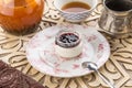 Dessert panna cotta with cherry jam and cup of black tea on oriental wooden table Royalty Free Stock Photo