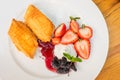 Dessert on plate with a strudel pie, sweet strawberries and a delicacy of mulberries and whipped cream. Concept of harmful sweet Royalty Free Stock Photo