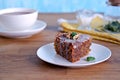 Dessert, a portion of carrot cake with walnuts and almonds on a white plate. Decorated with walnuts and icing Royalty Free Stock Photo