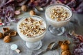 Dessert for a romantic breakfast: sweet, vanilla panna cotta with crushed walnuts in a beautiful glass on a gray