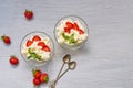 Dessert with sliced strawberries and cream cheese in the glass bowls on a gray background with copy space Royalty Free Stock Photo