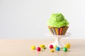 Dessert stand with tasty cupcake and candies on light wooden table