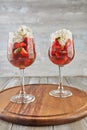 Dessert of strawberries and whipped cream in tall glasses on wooden background Royalty Free Stock Photo