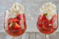 Dessert of strawberries and whipped cream in tall glasses on wooden background Royalty Free Stock Photo