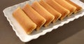 dessert on the table. strudel with fruit filling on a white plate. pastries on a brown background.