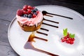 Dessert tart with cream, honey and fresh berries on a white plate. Close up. Delicious treat Royalty Free Stock Photo