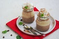 Dessert, two-layer chocolate and coffee panna cotta, decorated with whipped cream, in vintage glass jars on a light concrete Royalty Free Stock Photo