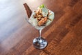 white ice cream, peanuts and a chocolate bar with a mint leaf in a glass bowl on a wooden table Royalty Free Stock Photo