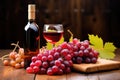 dessert wine bottle behind red grapes on a wooden table Royalty Free Stock Photo