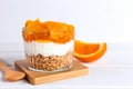 Dessert of yogurt, jam, orange and granola on a white wooden table. Healthy food. Breakfast