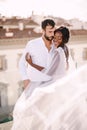 Destination fine-art wedding in Florence, Italy. Multiethnic wedding couple. African-American bride hugs Caucasian groom