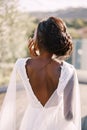 Destination graceful wedding in Florence, Italy. An African American bride stands with her back in urban dresses against