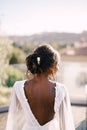 Destination graceful wedding in Florence, Italy. An African American bride stands with her back in urban dresses against