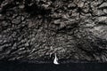 Destination Iceland wedding. Wedding couple under a rock of basalt stones. Bride and groom on the black beach of Vik. Royalty Free Stock Photo