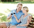 Destressing together. Happy mature couple toasting their love with two glasses of wine while outdoors. Royalty Free Stock Photo