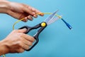 Destroy optical fiber with scissors. Isolated on blue Royalty Free Stock Photo