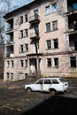 Destroyed abandoned house after the war in forsaken city, rusty car body