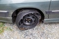 Destroyed blown out tire with exploded, shredded and damaged tire on a modern automobile.