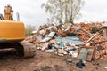 Destroyed, brick, residential building. Demolition of an old house with an excavator. Cleaning up a destroyed house with an
