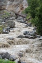 Destroyed bridge over rapid brown mountain river after rain