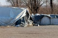 Destroyed broken old temporary flood protection wall made of box barriers and sandbags covered with thick geotextile fabric