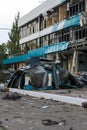 Destroyed civil infrastructure building pile of fragments and broken glass in front of it. Military drones attack aftermath