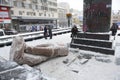 Destroyed monument to Lenin on Shevchenko boulevard, sculpture without head lying on pavement, people taking picture of