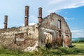 Destroyed old brick house without roof and with chimneys, broken windows, window frames, door and bricks Royalty Free Stock Photo