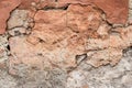 Destroyed old clay wall, abstract brown background. Cracked grunge surface, texture. Damage of facade building. Danger of collapse