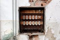 Destroyed old fuse box surrounded with crumbling wall