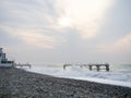 Destroyed pier under the waves. Bad weather at sea. Beautiful seashore with old architecture Royalty Free Stock Photo