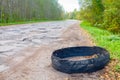 Destroyed rubber car tire car on rural bumpy broken road. Royalty Free Stock Photo