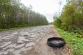 Destroyed rubber car tire car on rural bumpy broken road Royalty Free Stock Photo