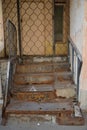 Destroyed rusty metal staircase to door of old brick house