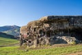 Destroyed Second World War Polish bunker on hill with mountains and meadow in the background during sunny day. Wegierska Gorka,
