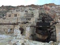Destroyed sulfur factory in the mountains. Broken brick buildings. Old ship close up. Greece. Milos island