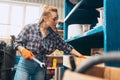 Destroying gender stereotypes. Young woman auto mechanic working at auto service station using different work tools