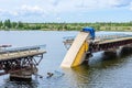 Destruction of bridge structures across the river with the collapse of sections into the water